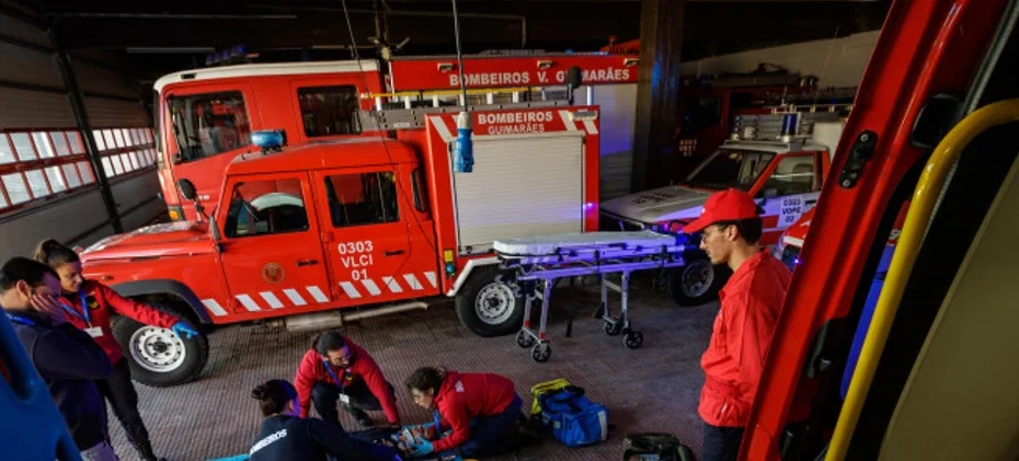 Quartel de bombeiros com operacionais a treinar e viaturas